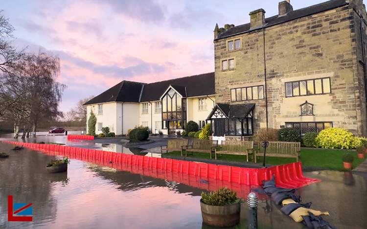 sunset scene of a historical building being protected from flooding by the noaq boxwall with the floood solutions uk logo in the corner